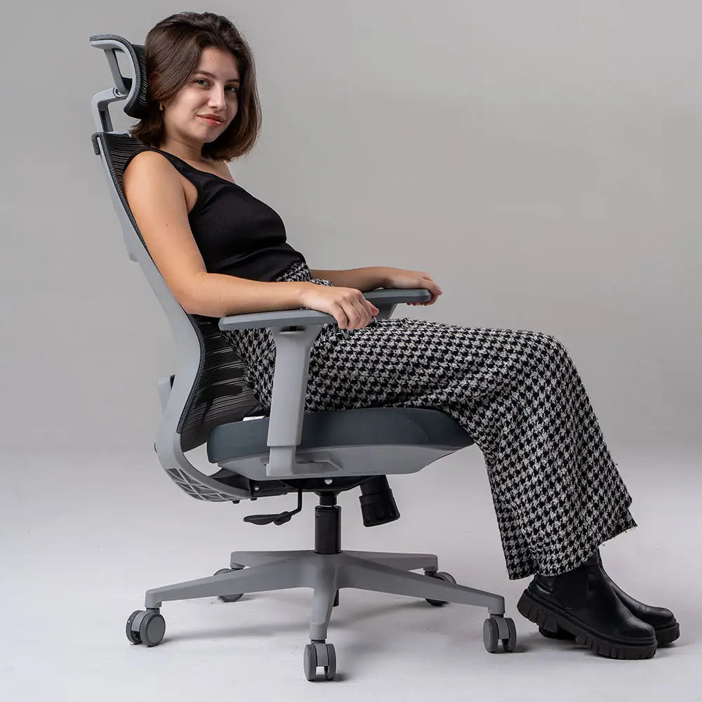 a imagem mostra uma Cadeira ergonômica de escritório Vertta com revestimento do encosto em mesh e assento de espuma injetada, apoio de braços ajustáveis e base com rodízios, na cor cinza.