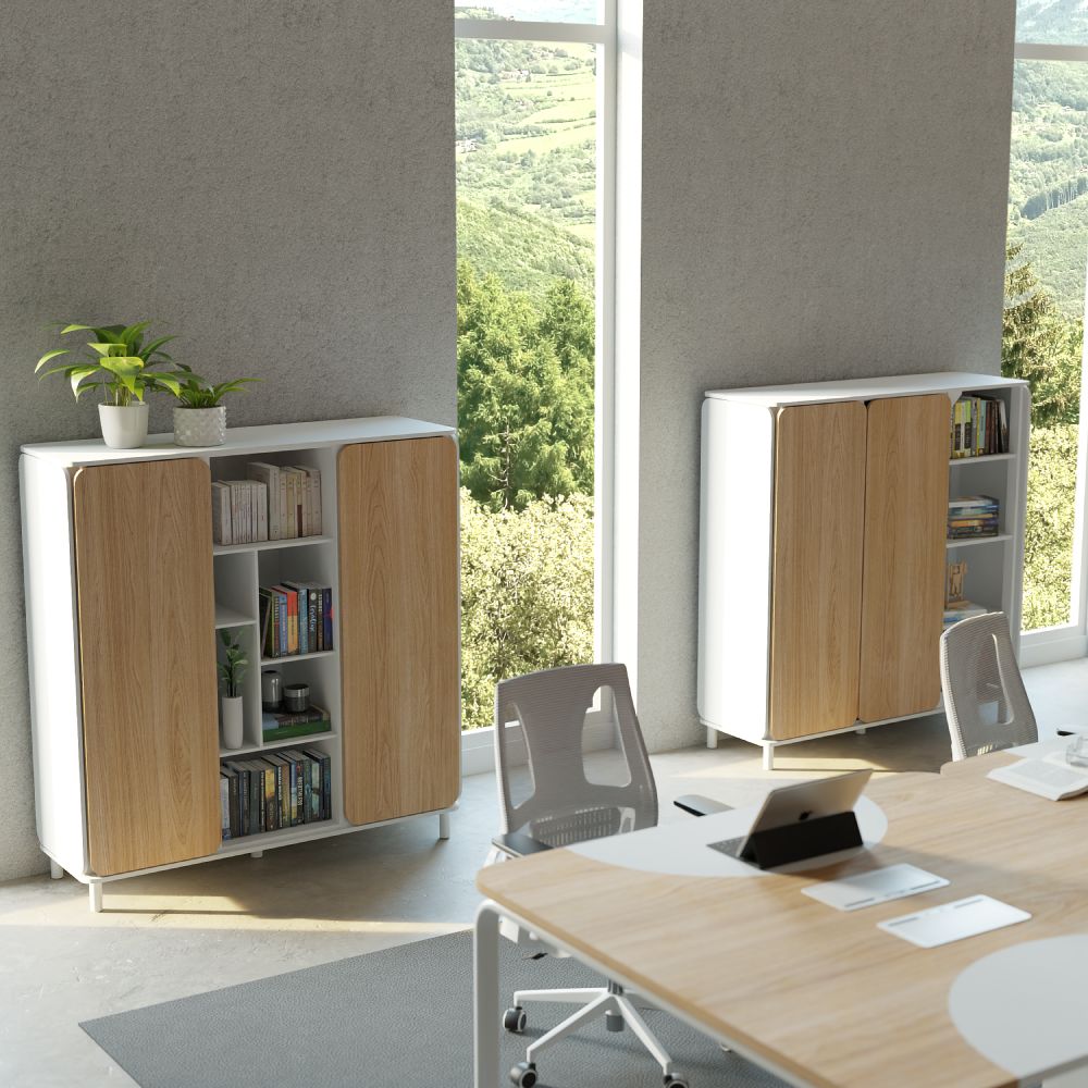 Na imagem se mostra uma sala de escritório com uma mesa central e dois armários Appennini Large que é um móvel versátil com design moderno, composto por duas partes principais: um armário com portas de correr e uma estante com prateleiras abertas. A combinação de madeira clara e branco confere um ar elegante e clean ao móvel, que se adapta a diversos ambientes.