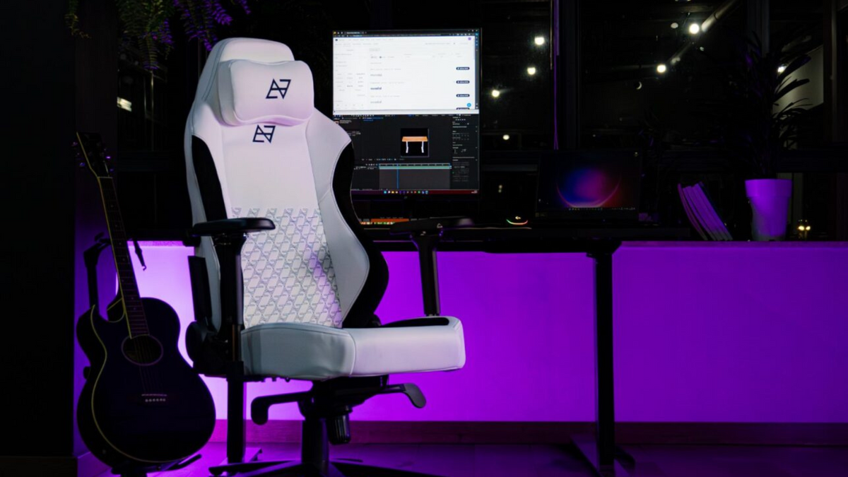 Escritório com um setup completo e uma cadeira branca gamer, a Lunari da Elements, como destaque no primeiro plano.