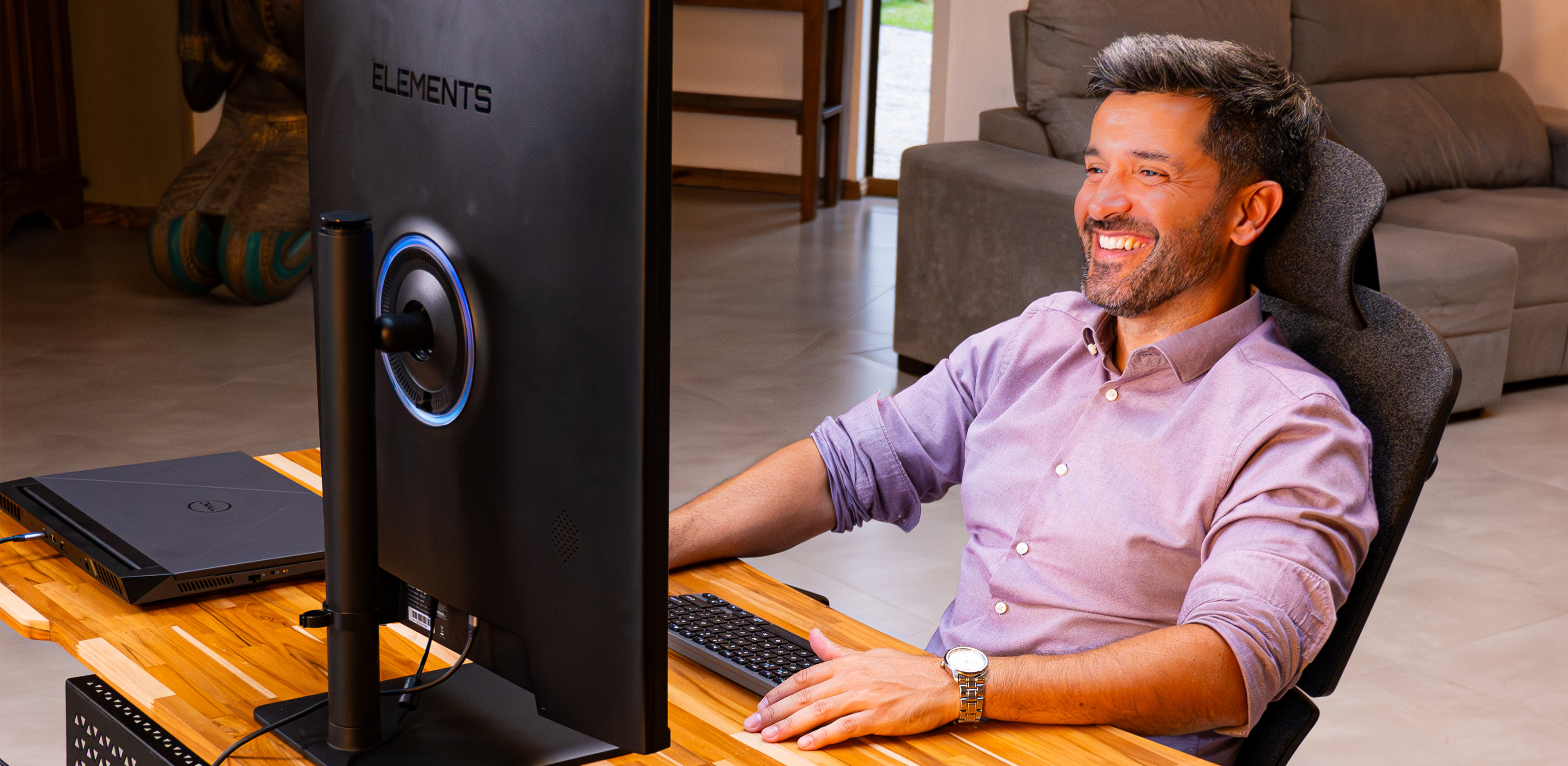 homem sorridente trabalhando em uma cadeira elements Nemesis olhando para um monitor 2030