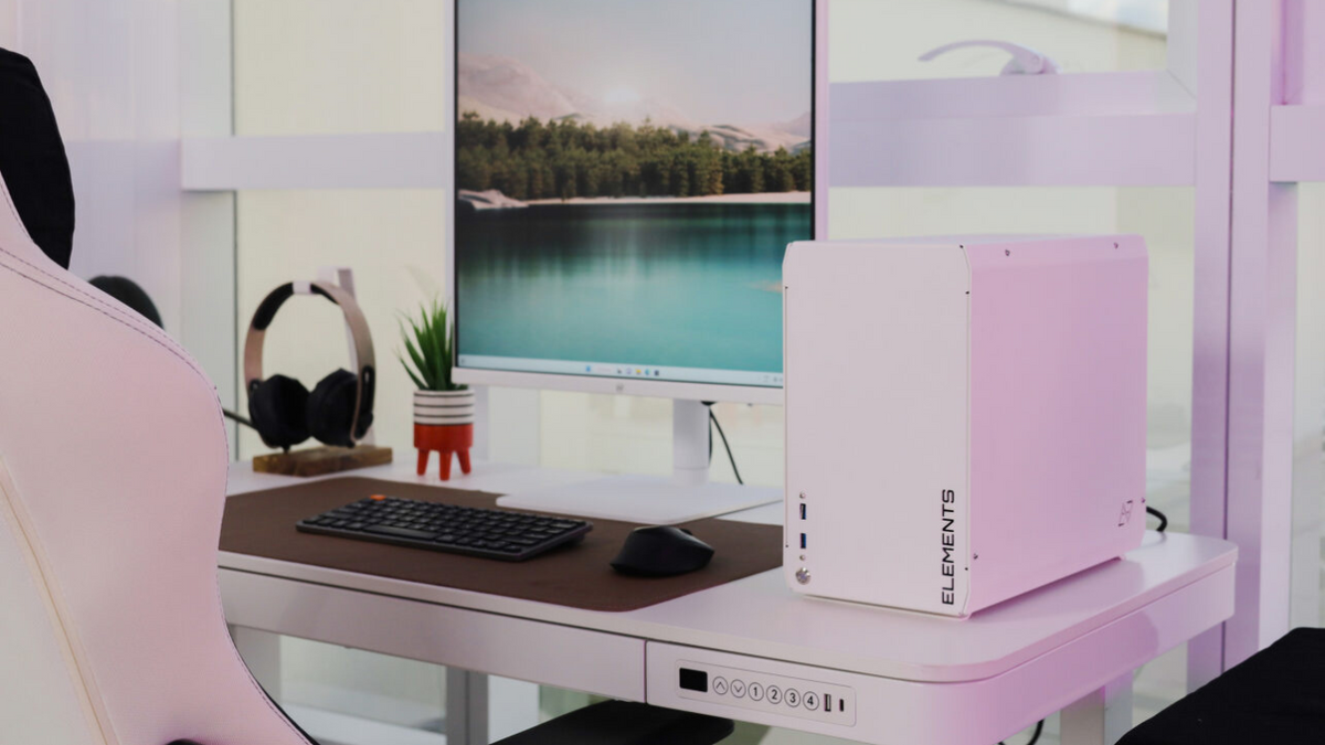 A imagem mostra um escritório com vários produtos da Elements: monitor, mesa, computador, porta headset, headset, mousepad e cadeira.