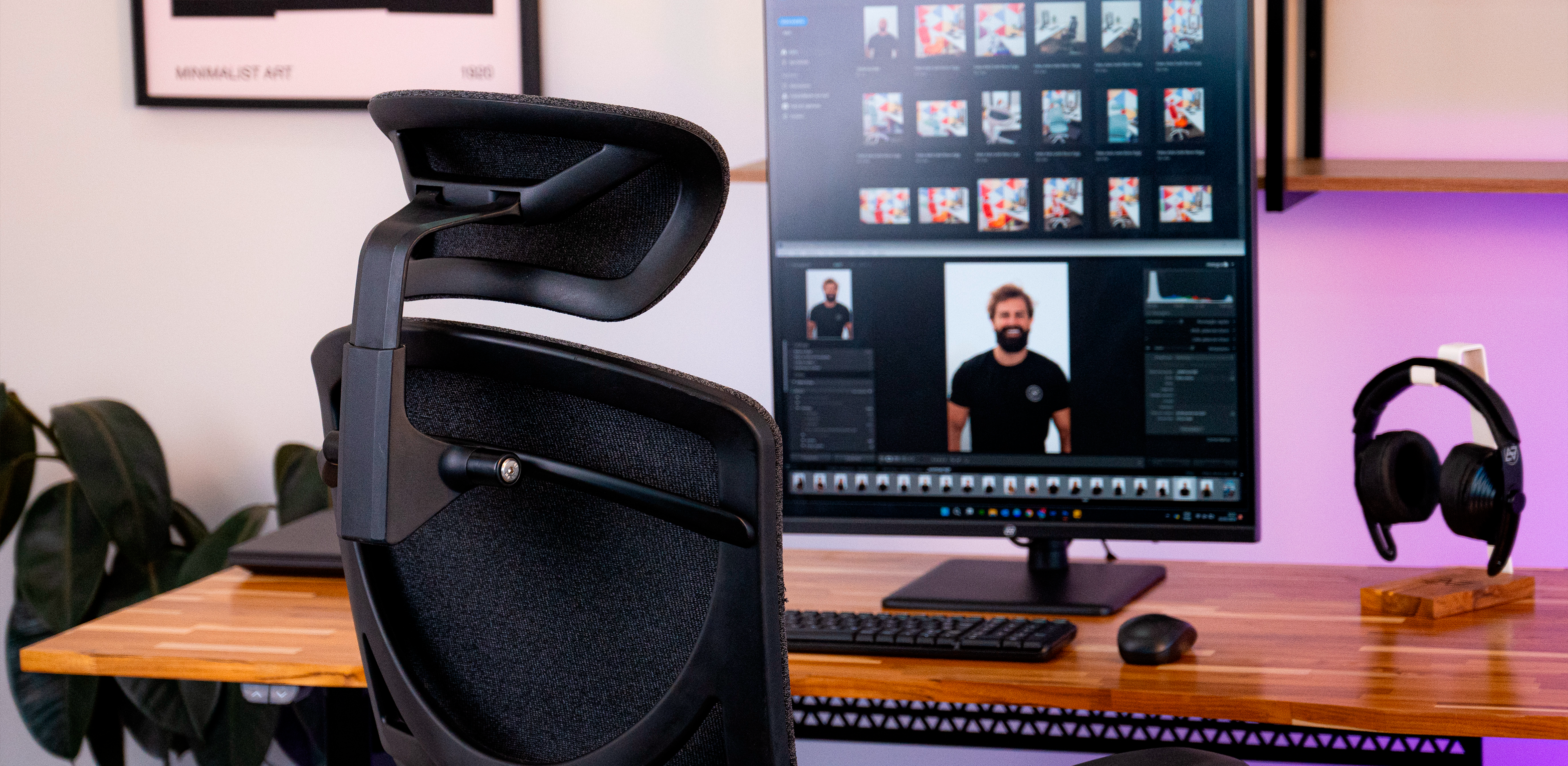 Cadeira Ergonômica Elements, em frente a uma mesa com regulágem de altura elétrica com fone de ouvido e um monitor com software de edição de vídeo